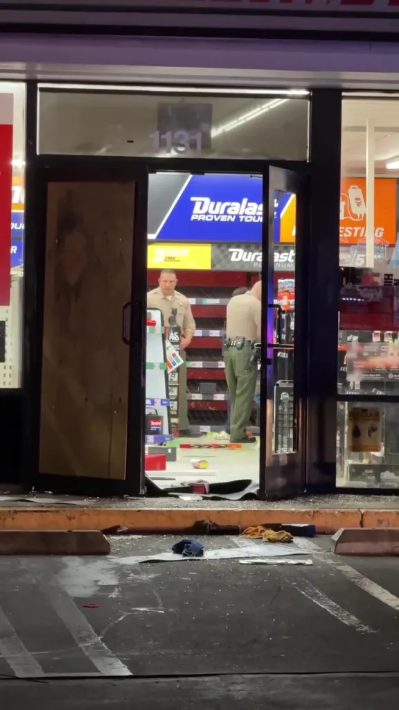 Two sheriff's deputies inspect a ransacked AutoZone store in East Los Angeles.