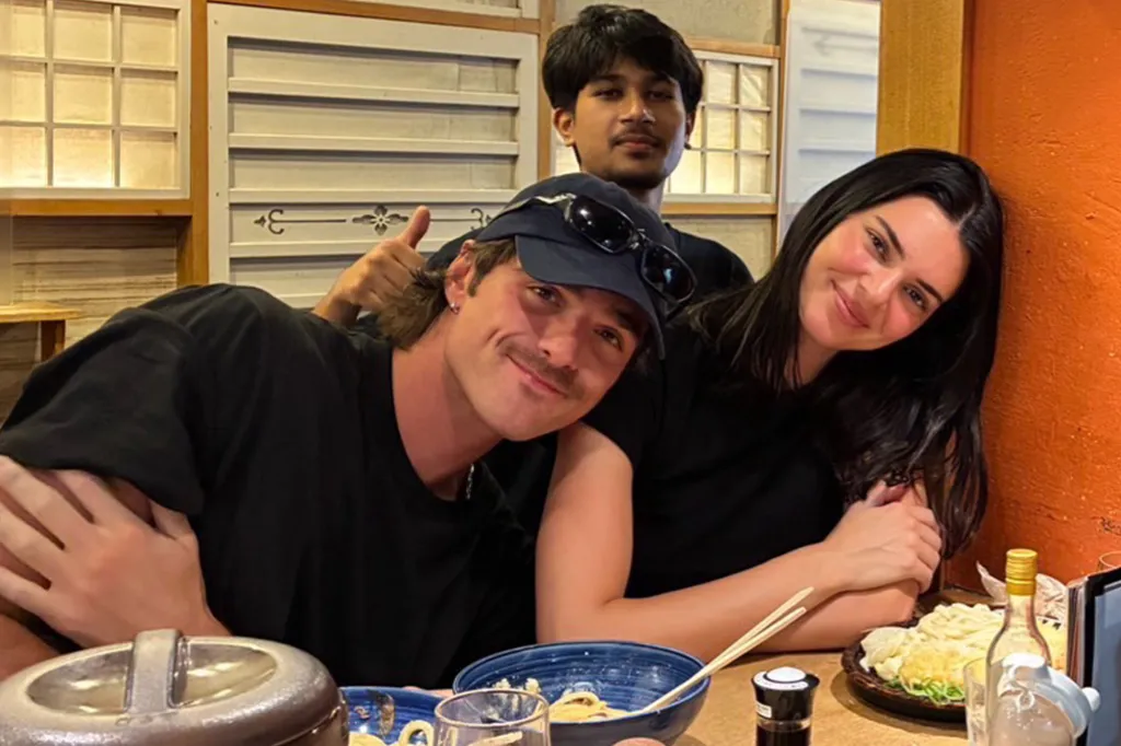 Three people posing for a photo at a table in a restaurant.