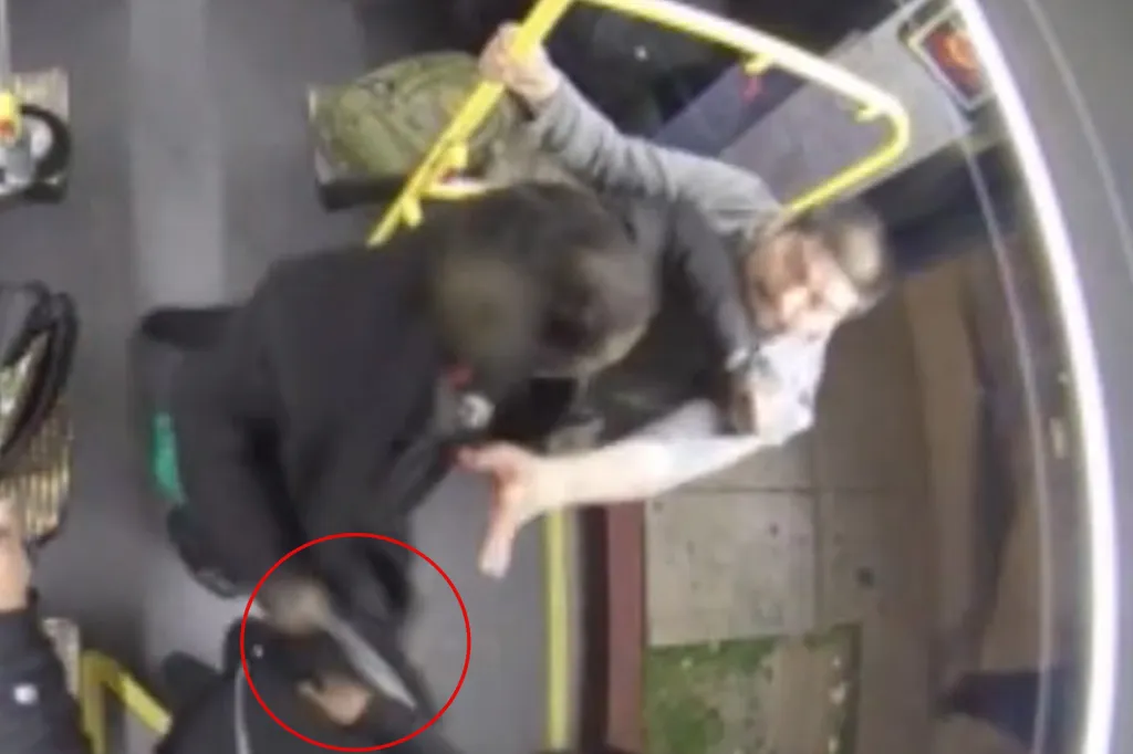 CCTV footage of a person with a knife fighting another person in a bus doorway.