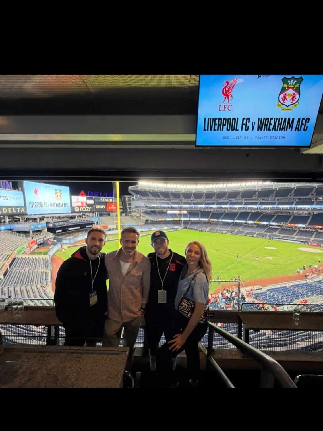 Ryan Reynolds and three other people pose for a photo at Yankee Stadium during the Liverpool FC vs. Wrexham AFC match.