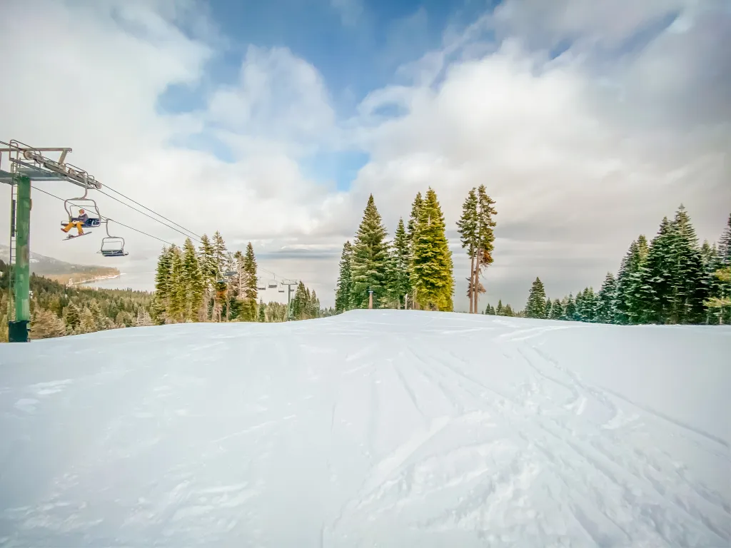 Ski slopes at Homewood Resort in Lake Tahoe with a skier on a chairlift.
