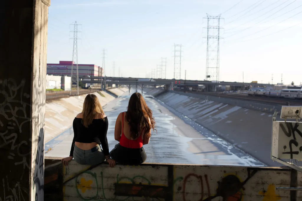 Two women looking out over the Los Angeles River.
