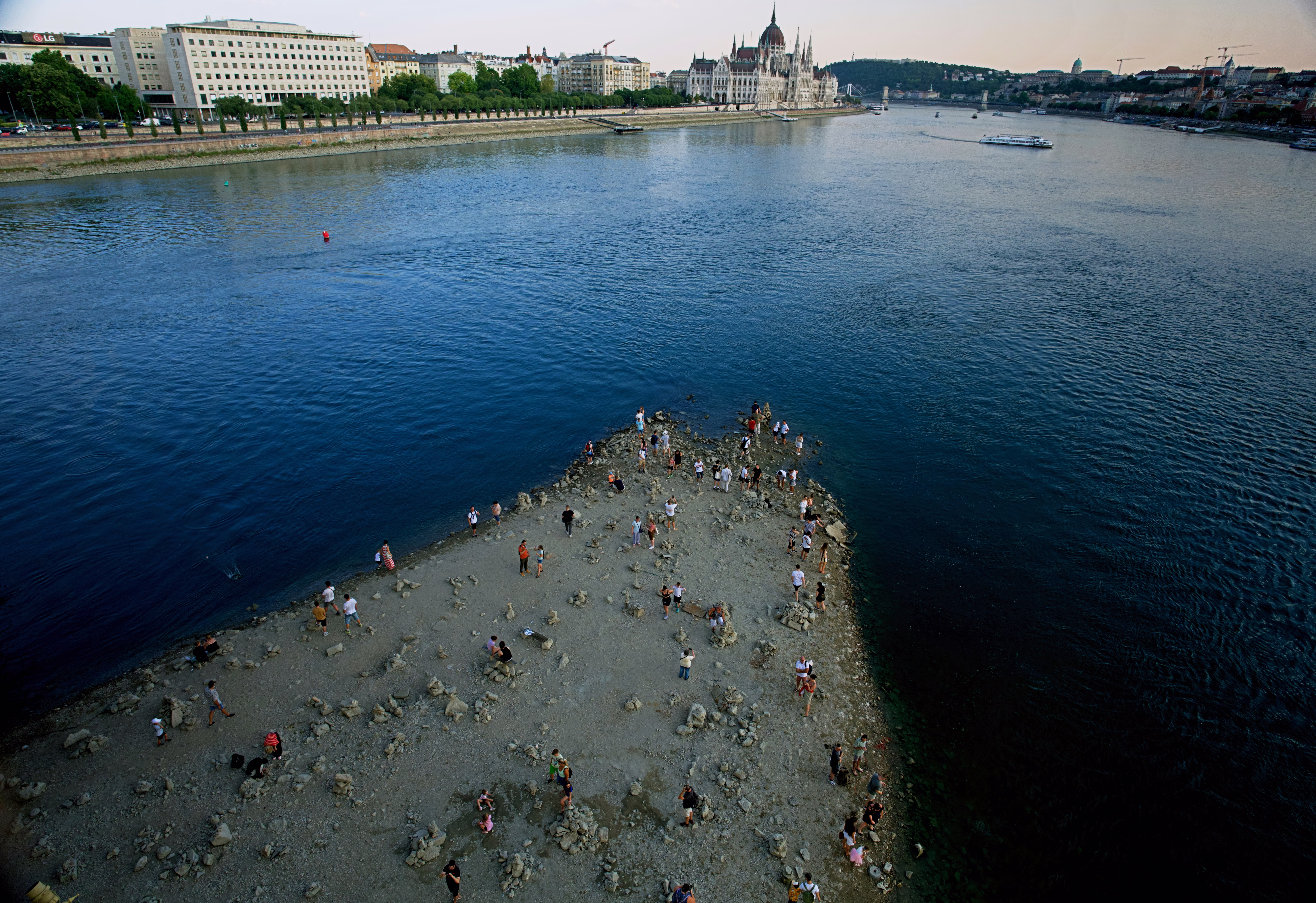 People walk on a sandbar in the middle of the Danube River in Budapest.