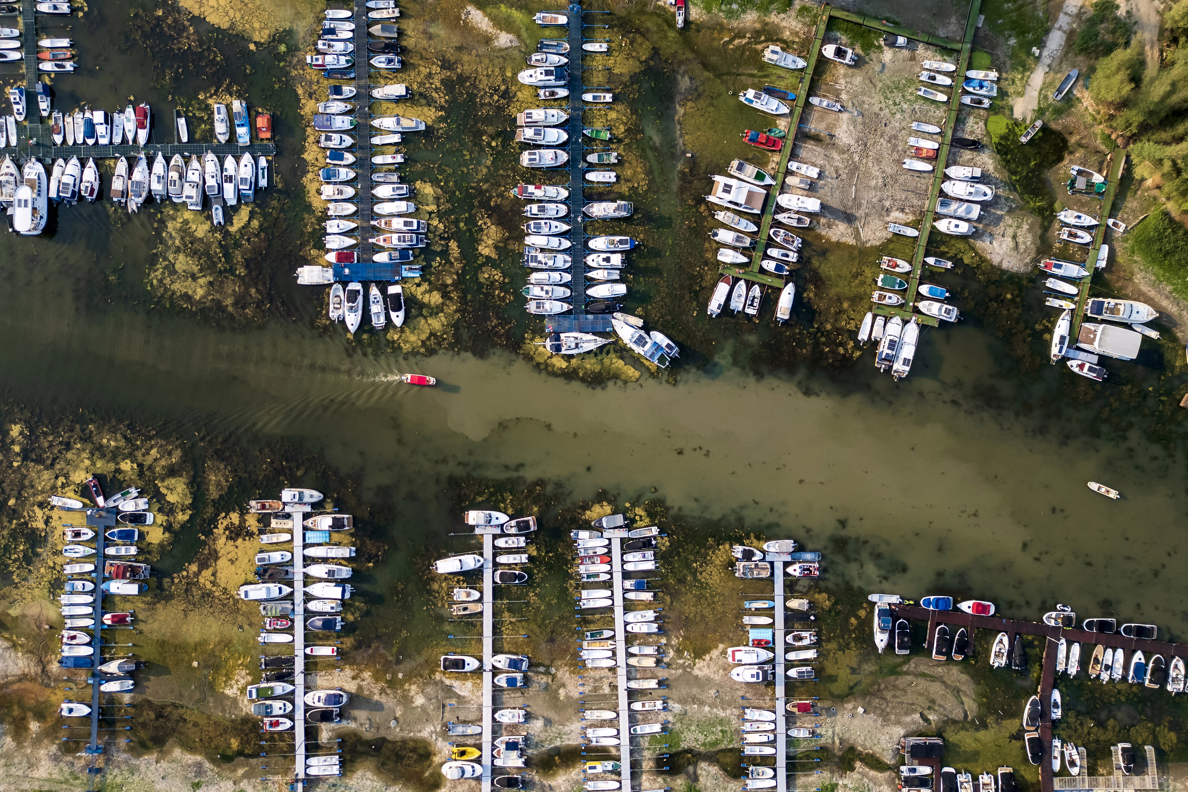 An aerial photo shows boats in a marina left stranded on a dry riverbed.