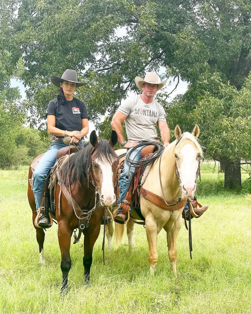Taylor Sheridan, in a grey T-shirt and blue jeans, and Nicole Muirbrook, in a navy blue T-shirt and blue jeans, on horseback.