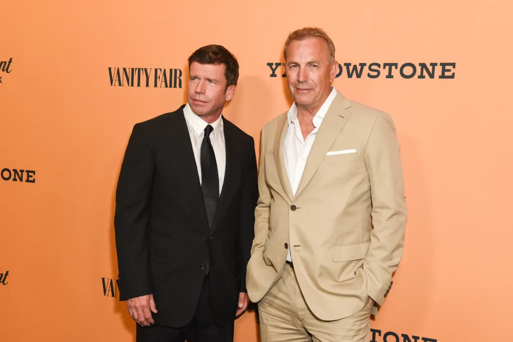 Taylor Sheridan, in a black suit, white shirt and black tie, and Kevin Costner, in a beige suit and white shirt, at the Yellowstone premiere.