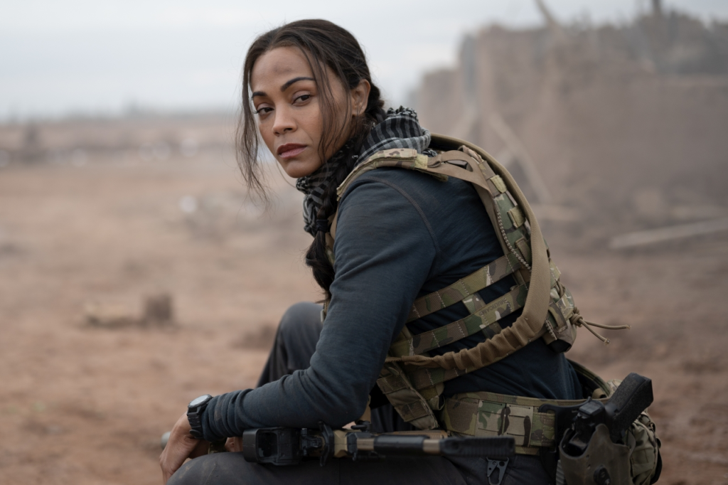 Zoe Saldana, in a black jacket, military weapons around her, as Joe in Special Ops: Lioness.