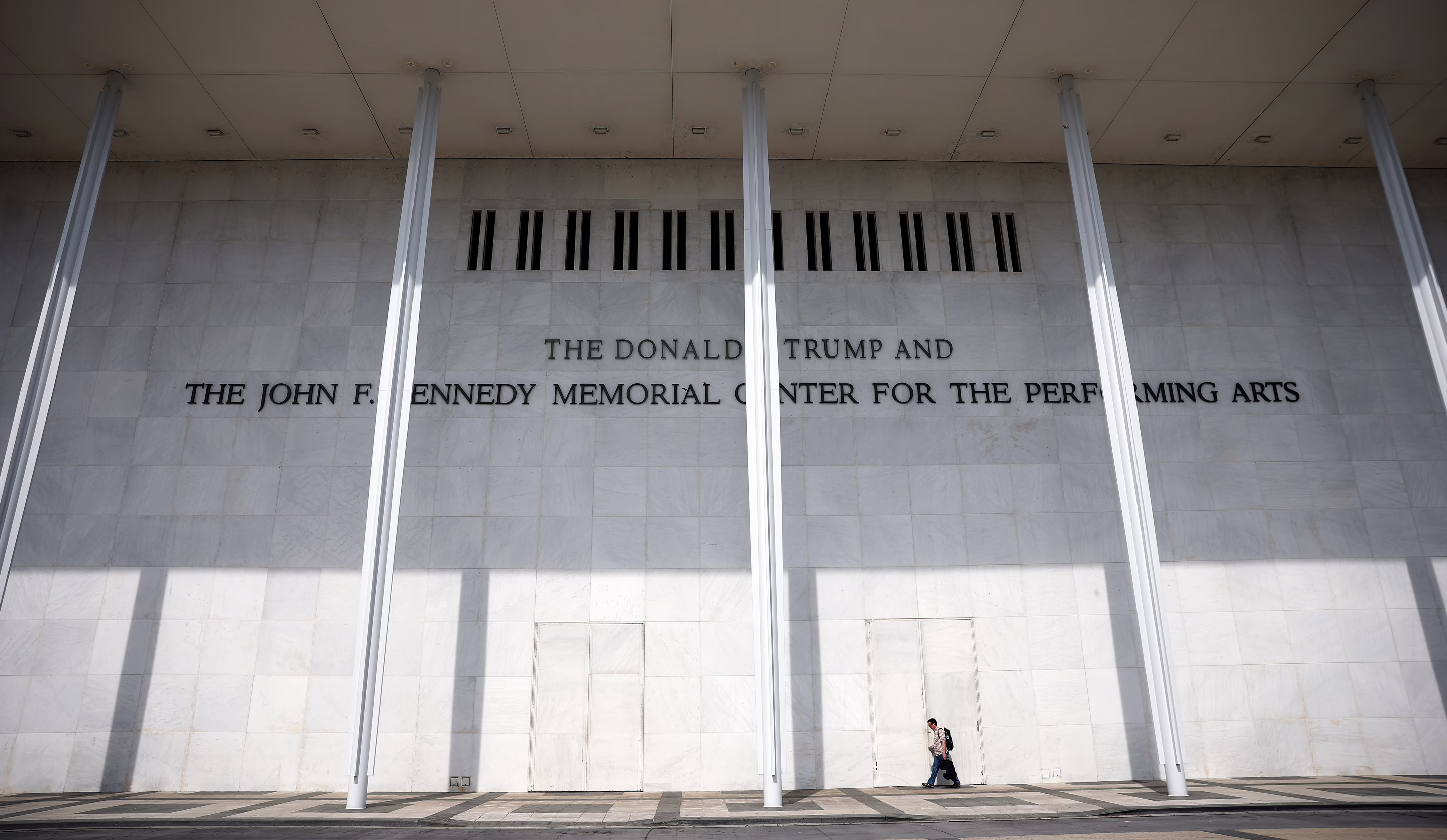 a person walks in front of the Kennedy Center 