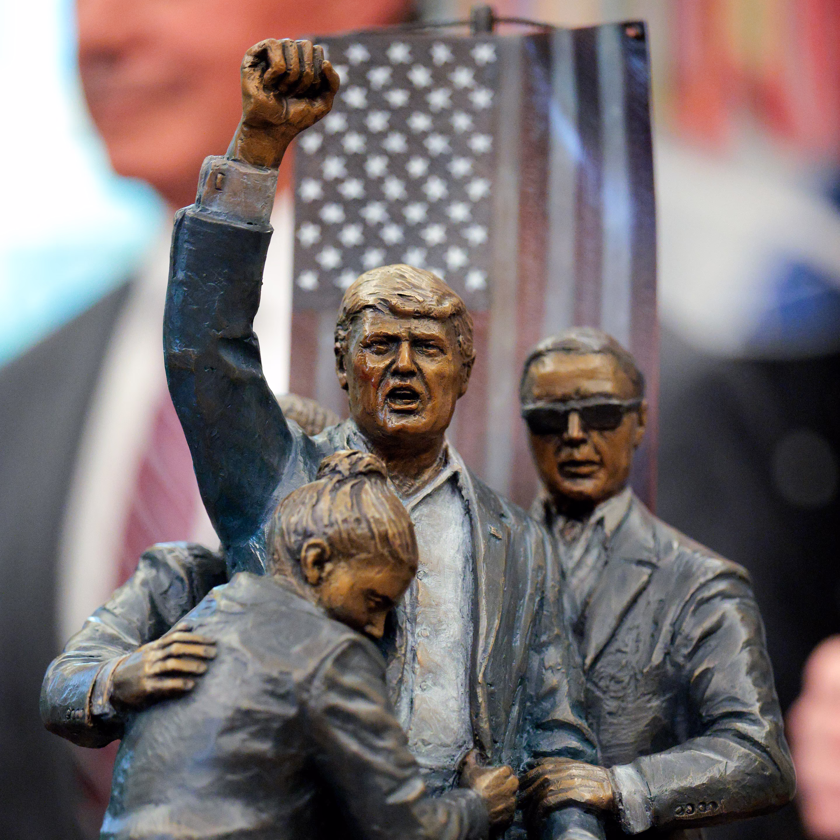 a sculpture of Donald Trump bleeding and raising his fist 