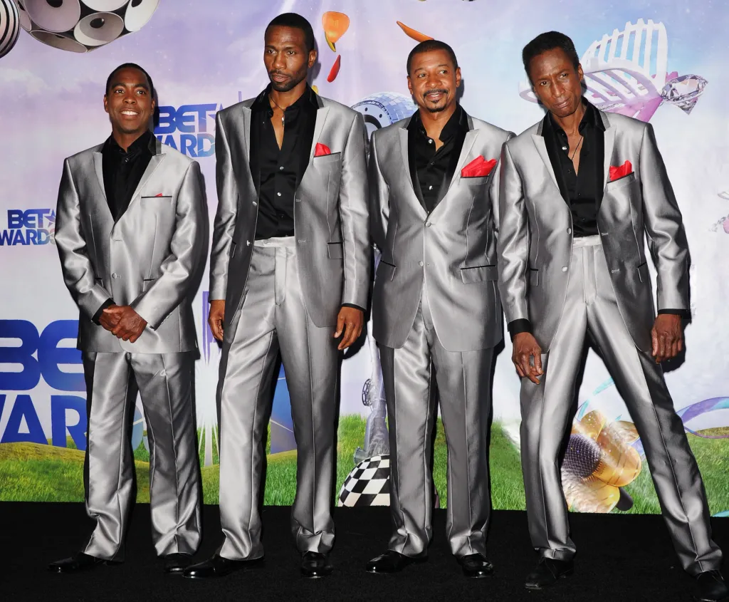 Tico Wells, Leon, Robert Townsend, and Michael Wright of the musical group The Five Heartbeats in silver suits.