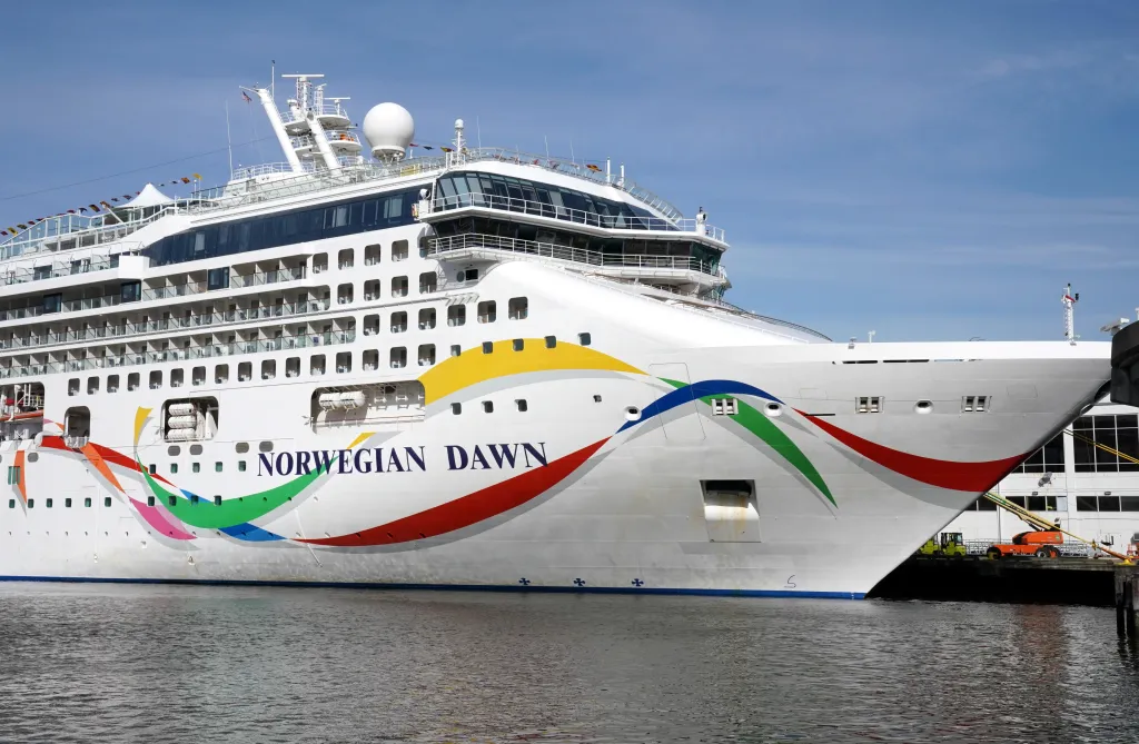 The cruise ship Norwegian Dawn docked in a port.
