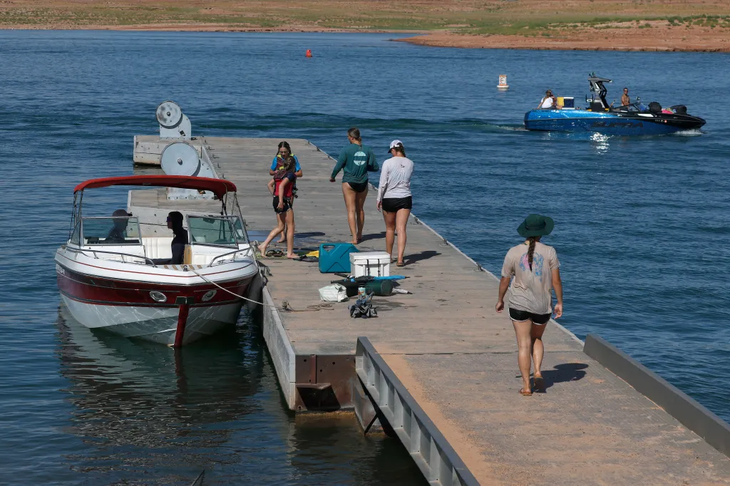 People disembarking boats at a dock at Lake Powell, where water levels are at historic lows.