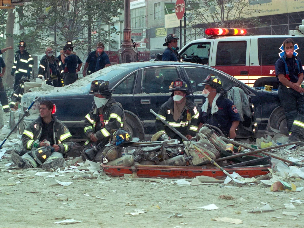 First responders sit among the debris of the World Trade Center after the September 11, 2001 terrorist attack in NYC.