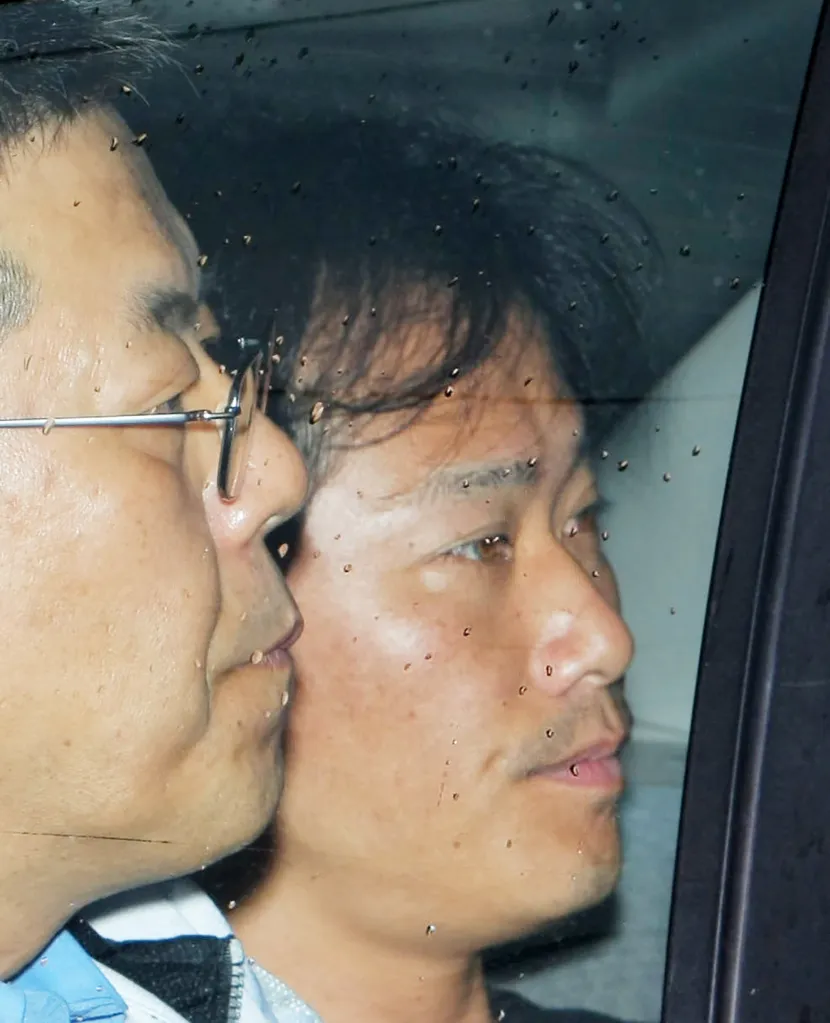 Prisoner Sunao Takami, an arsonist, is visible through a rain-streaked window.