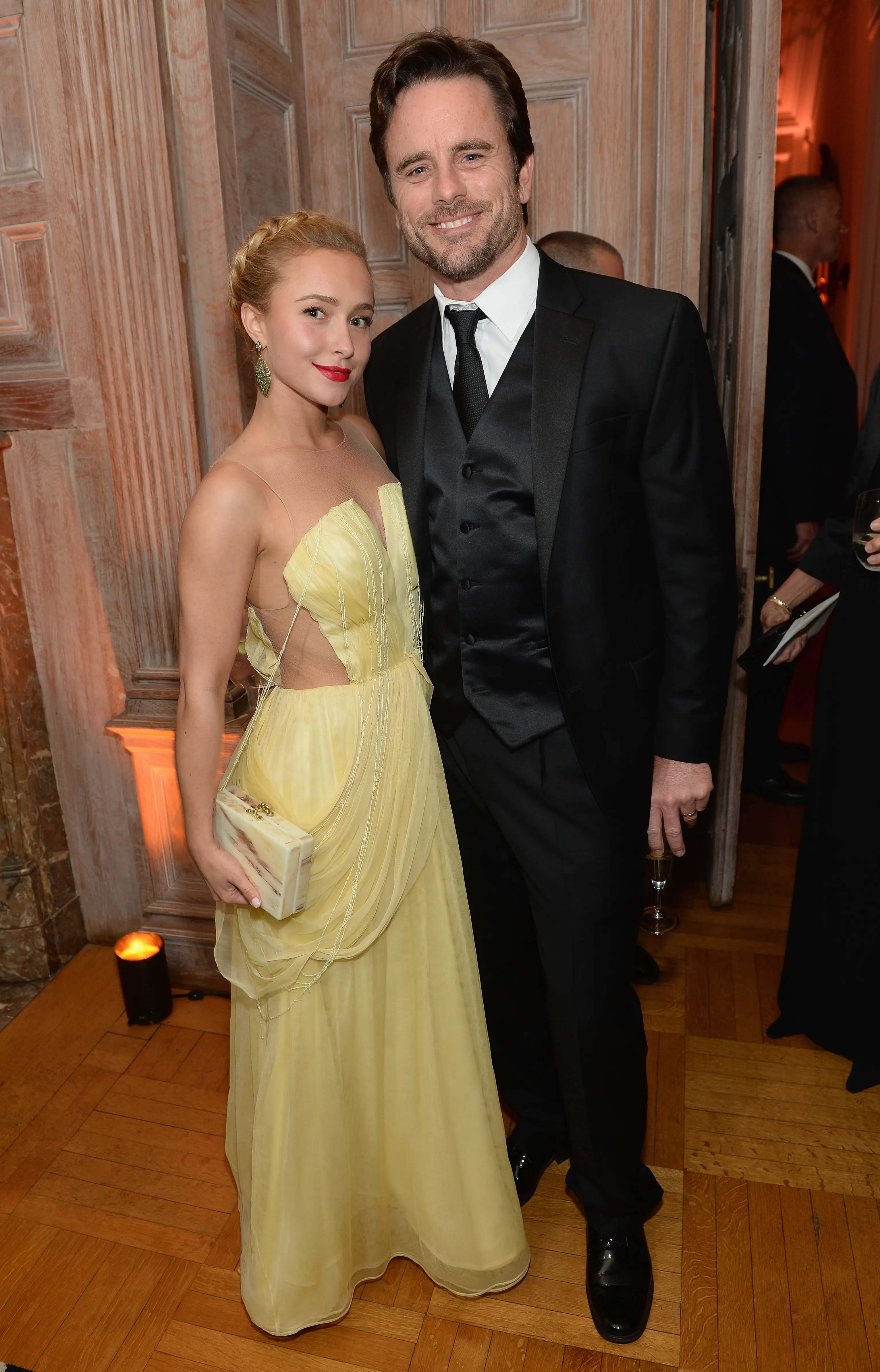 Hayden Panettiere in a yellow dress and Charles Esten in a black tuxedo smile at the camera.