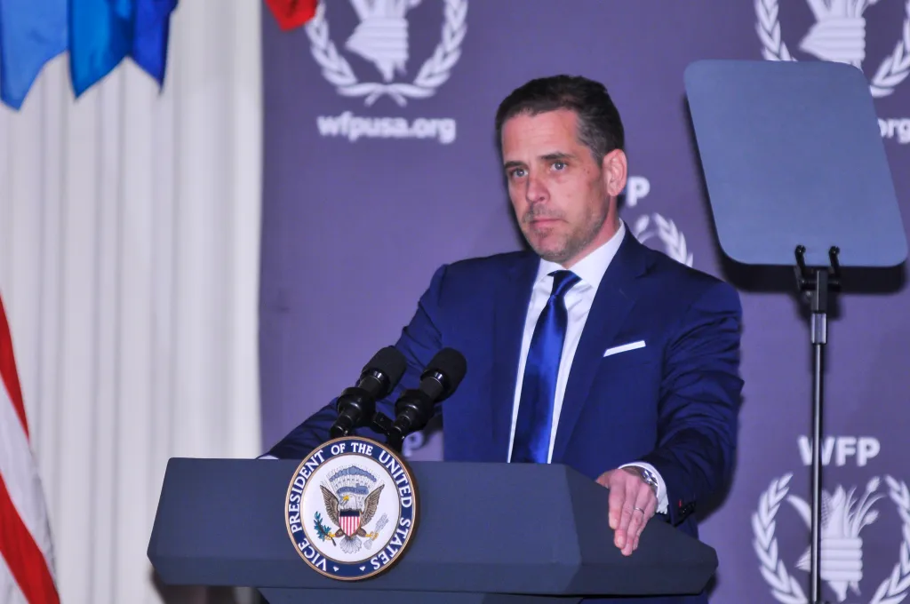 Hunter Biden, wearing a suit and tie, speaks at a podium with the seal of the Vice President of the United States.