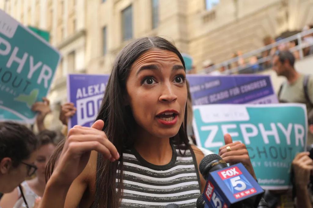 Alexandria Ocasio-Cortez speaks into a Fox 5 News microphone while campaigning for Zephyr Teachout.