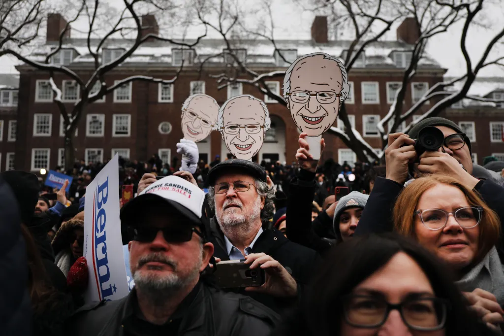 People attending a Bernie Sanders rally in Brooklyn, with some holding Bernie Sanders cutouts.