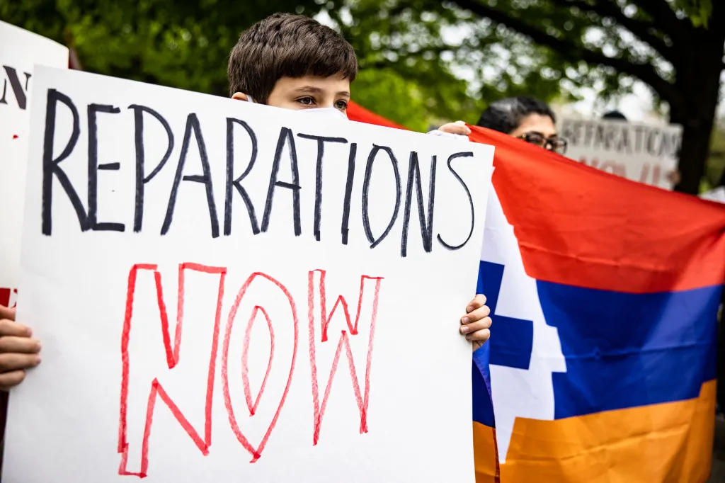 A boy holds a sign reading 