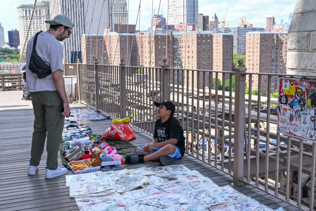 An 11-year-old boy selling merchandise on the Brooklyn Bridge.