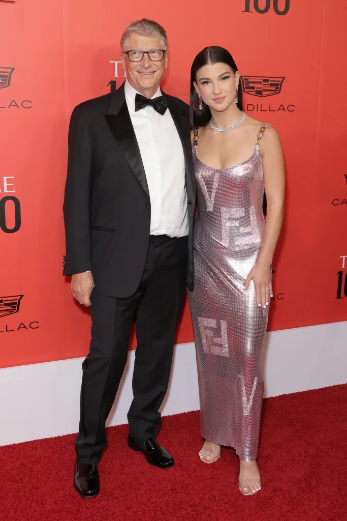 Bill Gates in a tuxedo and Phoebe Gates in a metallic pink dress with a Fendi pattern on the red carpet.