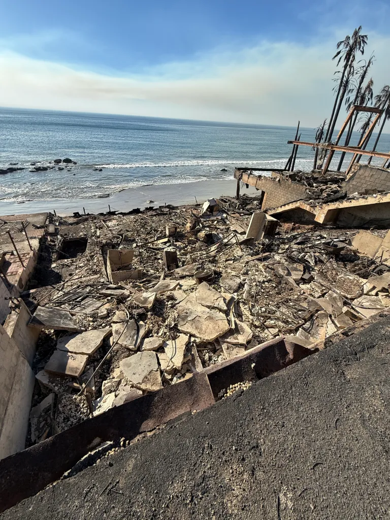 The remains of a Malibu home destroyed by the Palisades fire, with a view of the ocean.