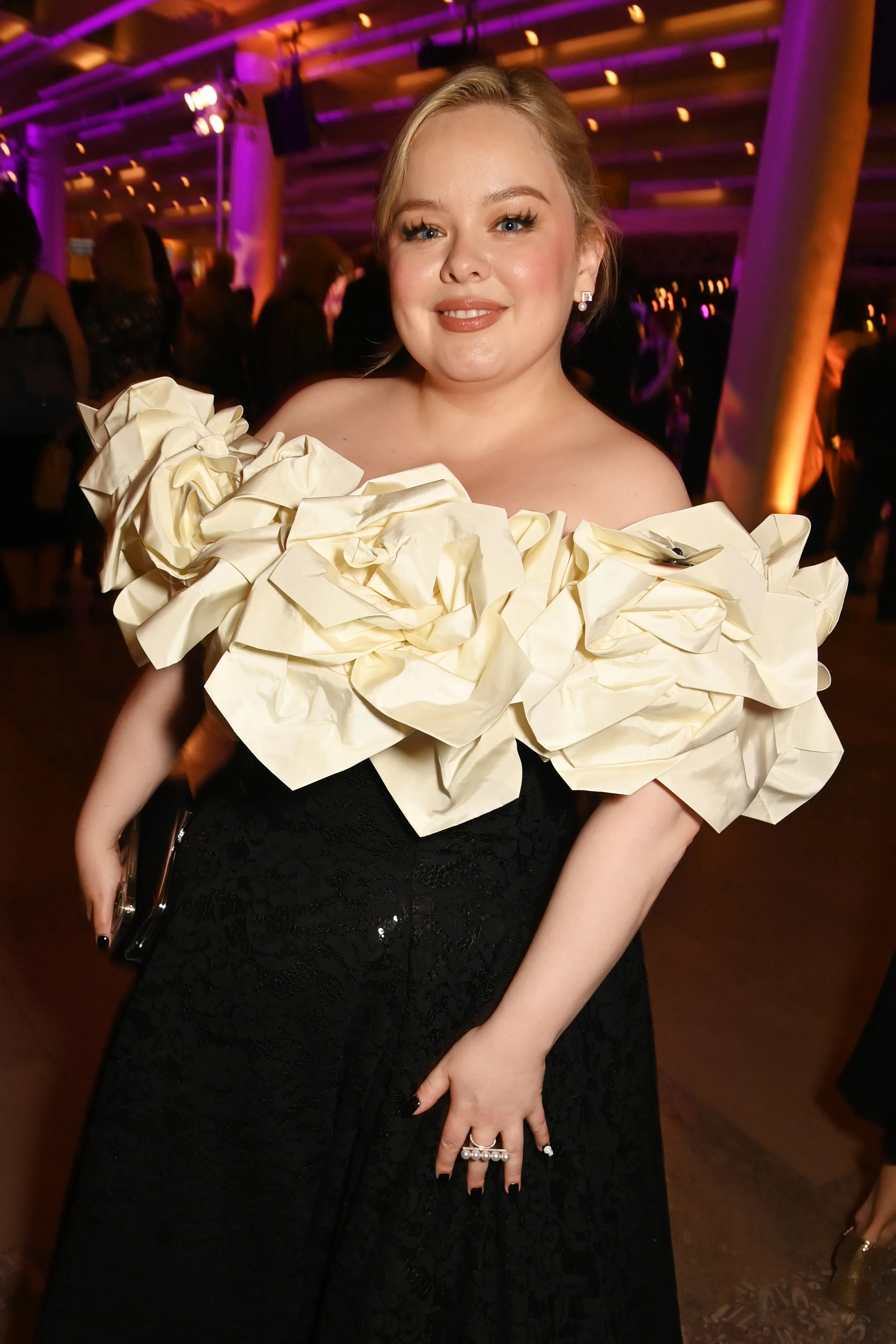 Nicola Coughlan poses in a black dress with a cream off-the-shoulder ruffled top at the BAFTA Television Awards dinner.