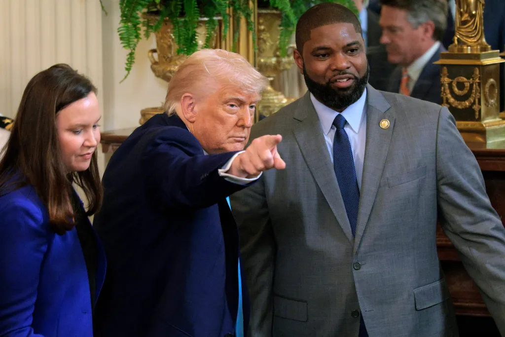 President Trump pointing while standing with Sen. Ashley Moody and Rep. Byron Donalds at a White House celebration.