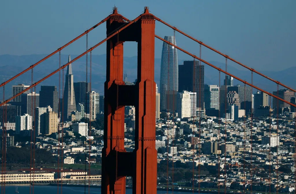 Aerial view of the Golden Gate Bridge with the San Francisco skyline in the background.