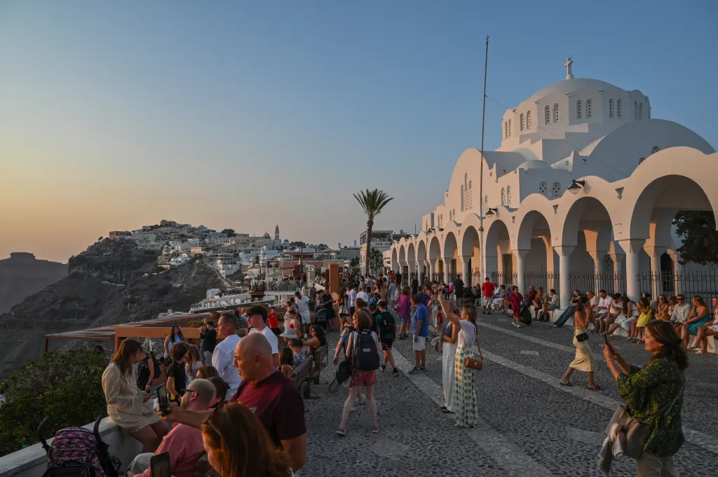 Tourists taking pictures of the sunset in Fira, Santorini.