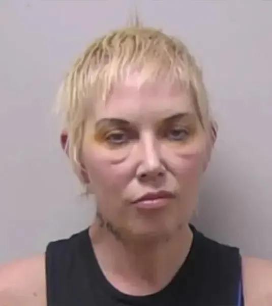 Mugshot of Kim Scott, Eminem's ex-wife, with bruised eyes and short blonde hair.