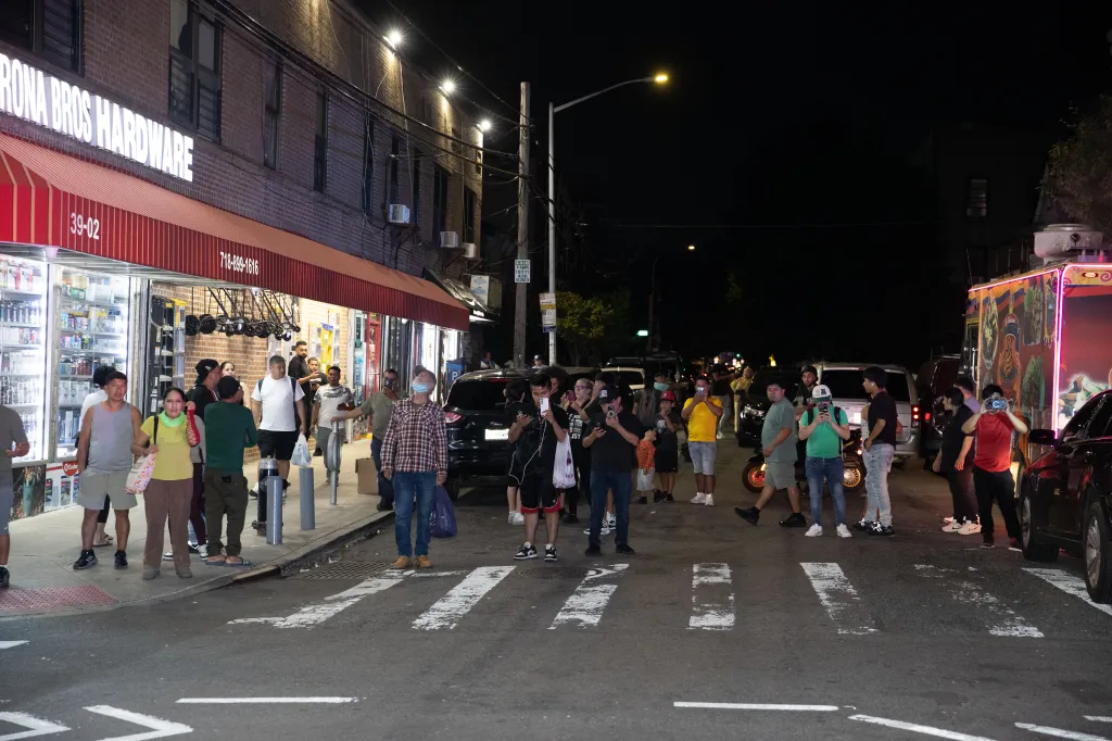 Onlookers gathered near a hardware store at the scene of a multiple shooting.