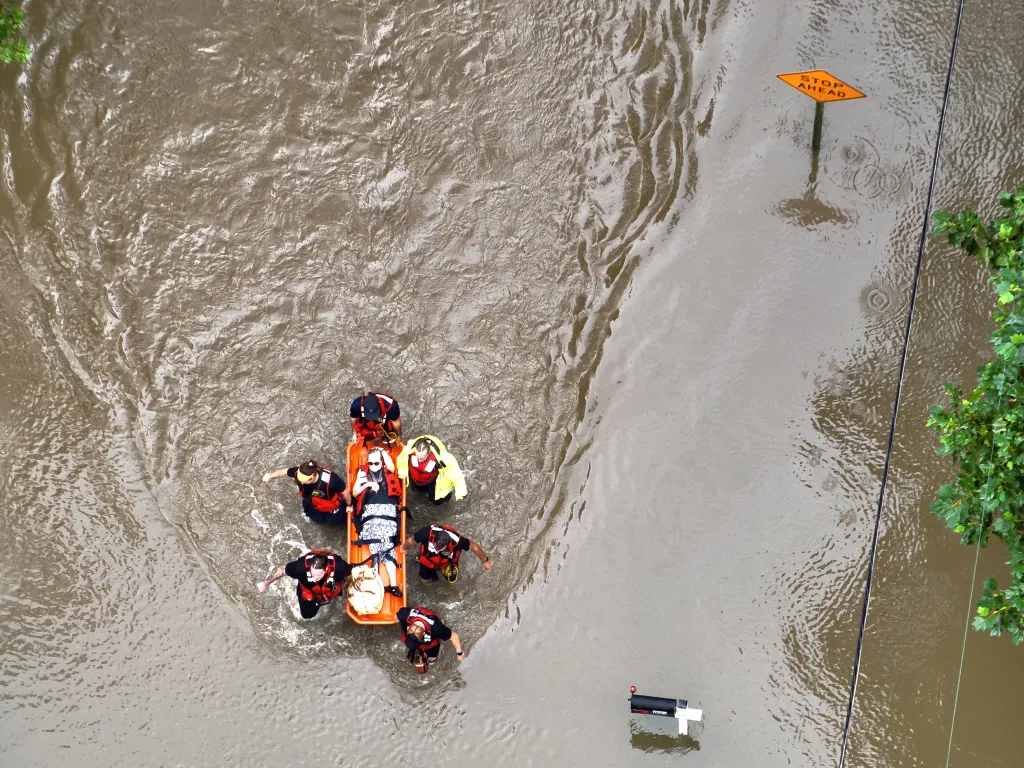 First responders rescuing a resident from floodwaters.