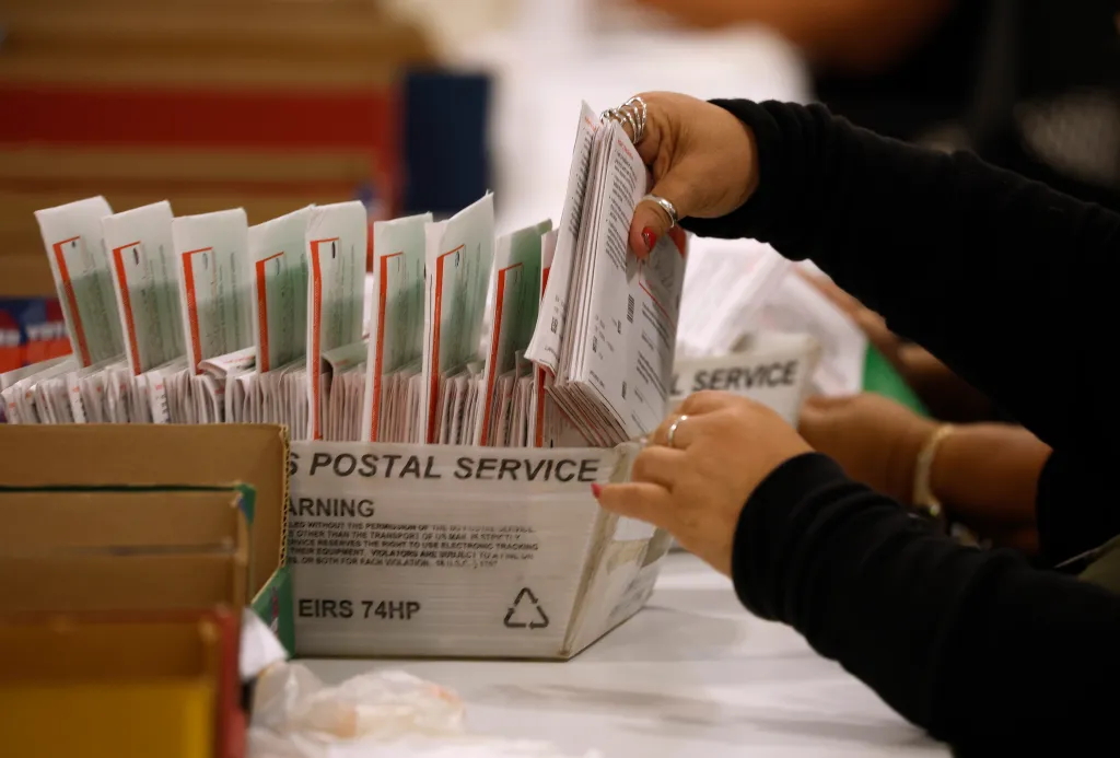 An election worker processes mail-in ballots.