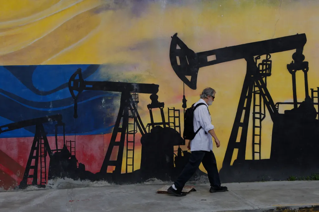 A pedestrian walks past a mural featuring oil wells in Caracas, Venezuela, on Aug. 29, 2026.