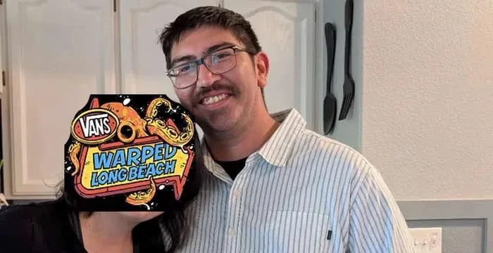 David Granado Jr. smiling with a Vans Warped Tour Long Beach sticker partially obscuring a woman's face next to him.