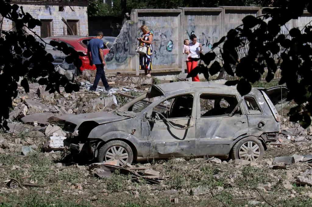 A destroyed civilian car lies near a sports ground by a school in Kyiv's Solomianskyi district after a Russian missile attack.