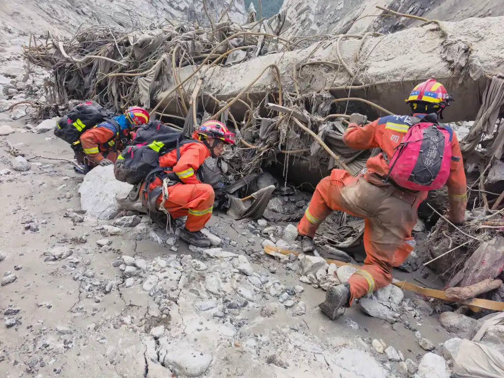 Rescuers search through mudslide debris in Gyirong County, Xizang.