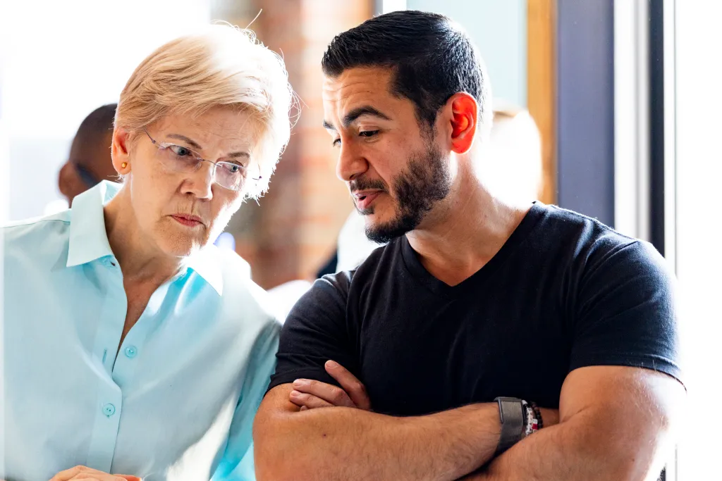 Elizabeth Warren speaks with Abdul El-Sayed backstage at a campaign event.