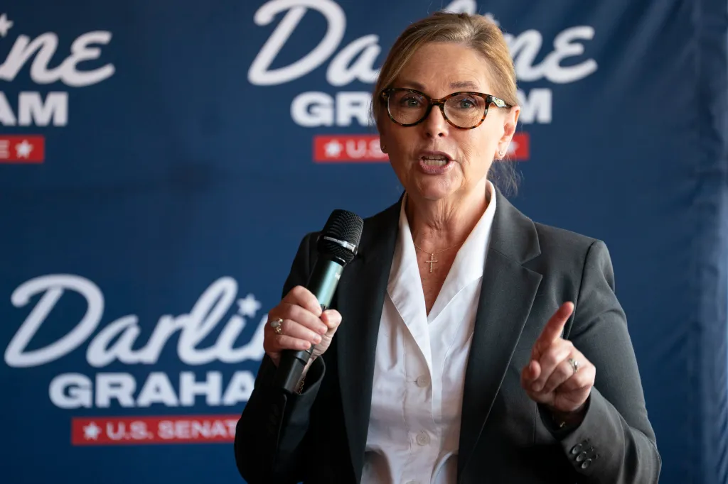 U.S. Senator Darline Graham speaks at a campaign event, holding a microphone in her left hand and gesturing with her right.