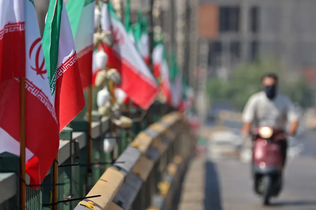 Iranian flags line a street as a motorist drives by.