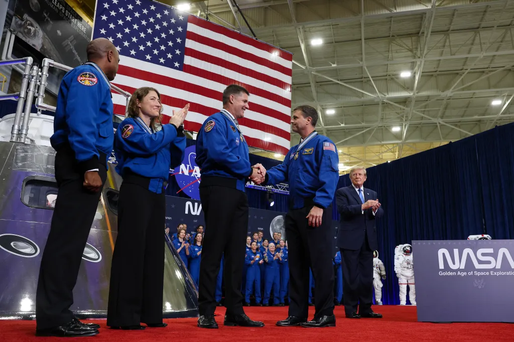 President Trump applauds as Artemis II crew members shake hands at NASA Johnson Space Center.