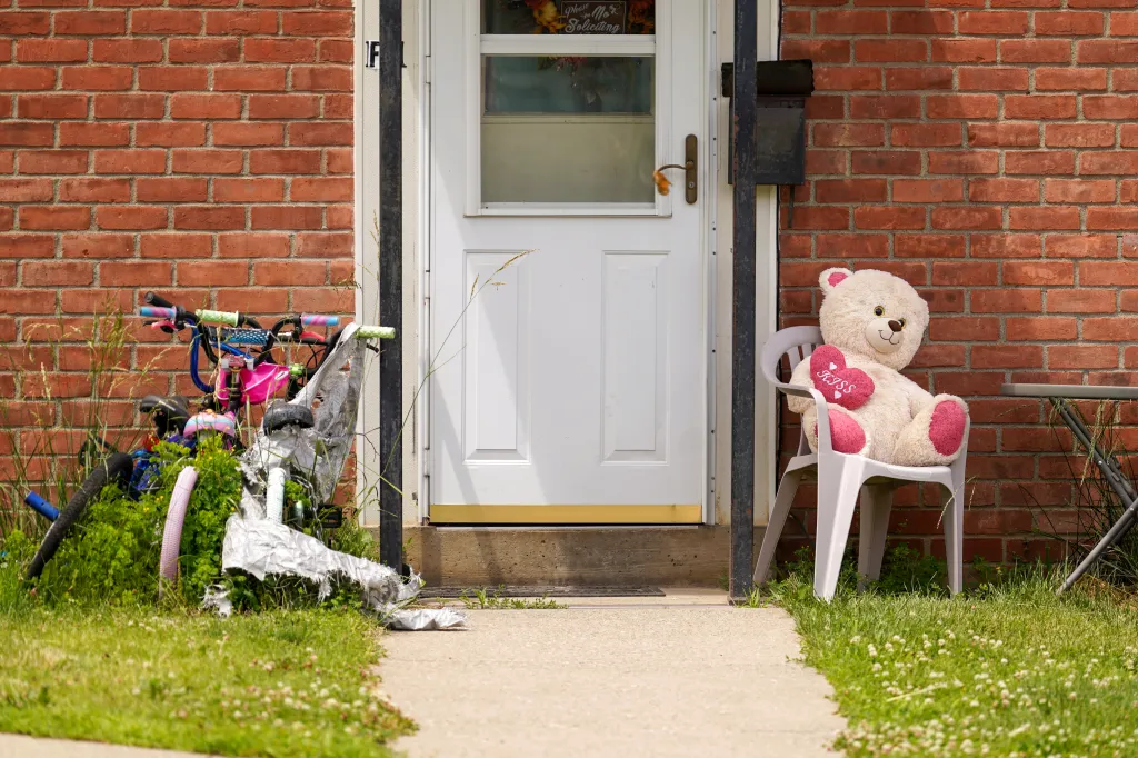 Apartment F1, the home of a family who perished, with a child's bike and a teddy bear outside.