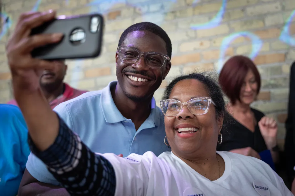 David Crowley, a Wisconsin gubernatorial candidate, and a woman take a selfie at a campaign rally.