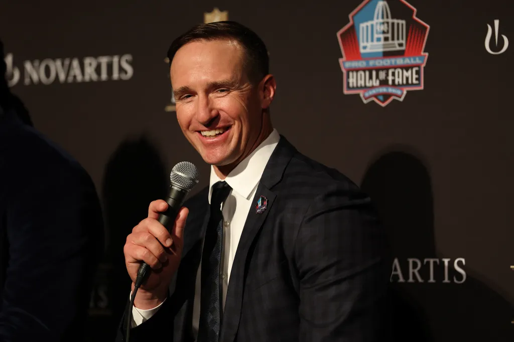 Drew Brees smiles while holding a microphone at the 15th Annual NFL Honors.