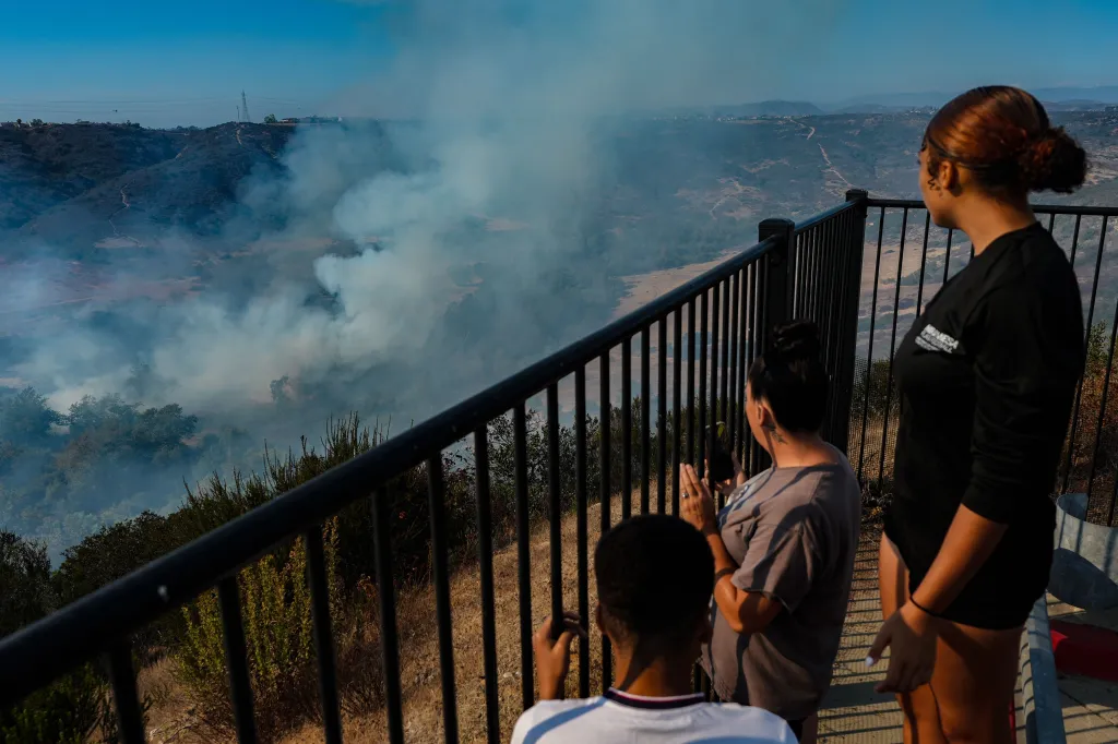 People observe the Sorrento Fire from a cliff in San Diego.