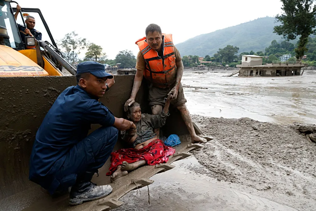 Rescuers transport an elderly woman in a tractor after a flash flood in Nepal.
