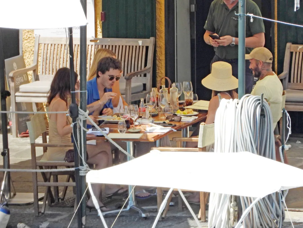 The Beckham family and friends enjoying drinks and gelato on a restaurant terrace in Portofino.