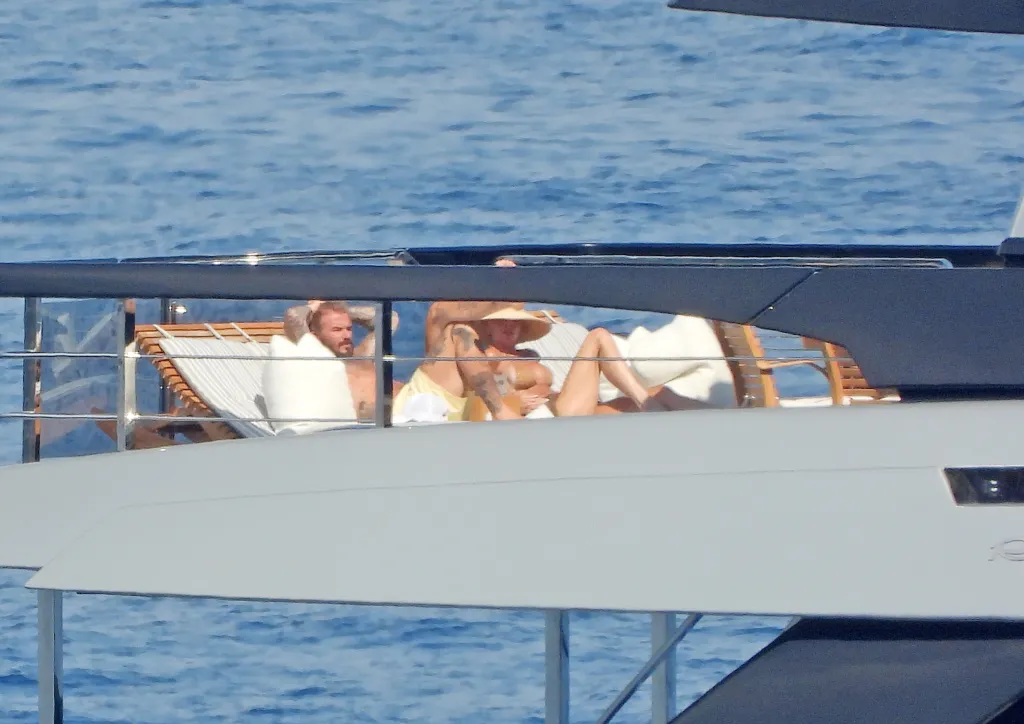 David and Victoria Beckham sunbathing on a luxury yacht.