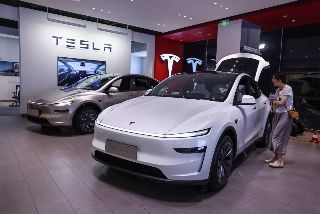 A woman looking at a white Tesla Model Y in a Tesla store in Beijing, China.